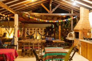 a patio with a table and chairs and a fireplace at Makai Suites in Ubatuba
