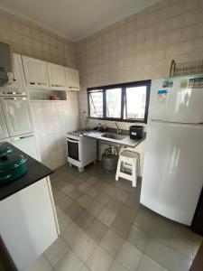 a kitchen with white appliances and a white refrigerator at Edifício Nautilus in Guarujá