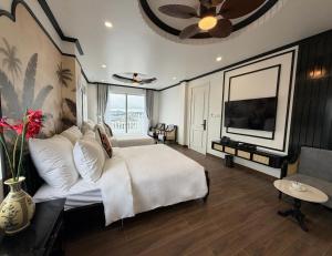 a bedroom with a white bed and a tv at Celine Privé - Dalat Hotel in Da Thien
