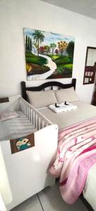 a bedroom with two beds and a painting on the wall at Pousada Anjo Gabriel in Penha