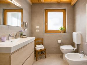 a bathroom with a sink and a toilet and a window at Chalet - Margherita in Sappada
