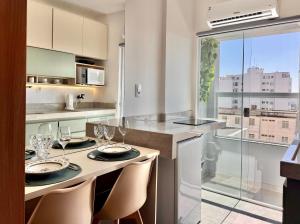 a kitchen with a dining table with glasses on it at Aurora Studio no Centro in Barbacena