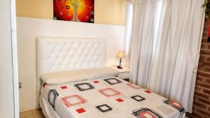 a bedroom with a bed with a white headboard at Casa cálida y confortable en Allen in Allen