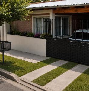a black fence in front of a house at Casa cálida y confortable en Allen in Allen