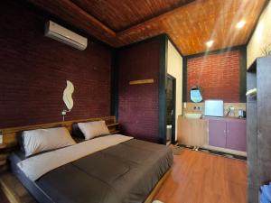 a bedroom with a bed and a bathroom with a sink at Tetebatu Valley Bungalows in Tetebatu
