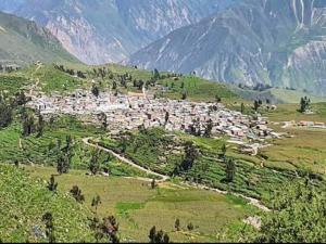 a small town on a hill with mountains in the background at Kaypi Yireh in Cabanaconde
