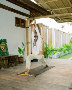 a man doing a handstand on a yoga mat at Kalyana Villa Gili Air in Gili Islands