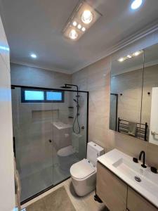 a bathroom with a toilet and a shower and a sink at Cara Luxe Stays at Regents Park near Olympic Park and DFO in Regents Park