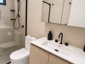 a bathroom with a sink and a toilet and a shower at Cara Luxe Stays at Regents Park near Olympic Park and DFO in Regents Park