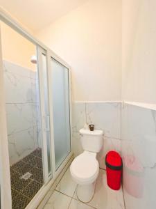 a bathroom with a toilet and a glass shower at Guadalupe House Esquipulas in Esquipulas +4 photos