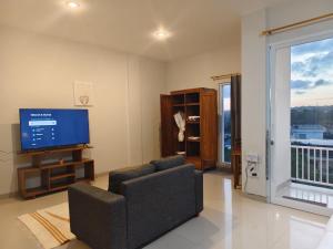 a living room with a couch and a flat screen tv at Sarining 2BR Villa With Pool in Uluwatu