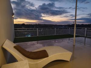 a chair sitting on a balcony with a sunset at Sarining 2BR Villa With Pool in Uluwatu