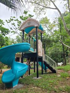 a playground in a park with a slide at Cozy Cottage by Chanita in Suan Phung
