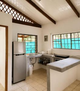 a kitchen with a stainless steel refrigerator and a sink at La Casita de Yan in Puerto Viejo