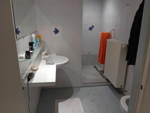 a white bathroom with a sink and a toilet at Kamer in Fermette Vlaamse Ardennen in Maarkedal