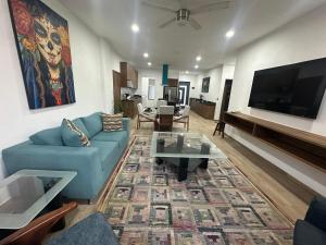 a living room with a blue couch and a table at Luxor and Condo Hotel in Ajijic