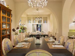 a dining room with a table and chairs and a chandelier at Le Royal Hotel Lyon - MGallery Collection in Lyon