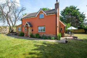 a orange house with a picnic table in a yard at 2 Bed in Wickhampton oc-t34449 in Wickhampton
