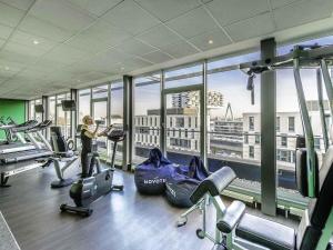 a woman in a gym with a view of the city at Novotel Köln City in Cologne