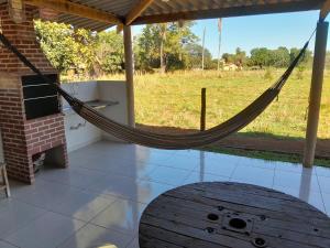 a hammock in a room with a view of a field at Rancho do Véio in Aquidauana