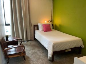 a bedroom with a bed with a green wall at Udee Bangkok Hostel in Bangkok
