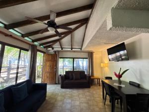 a living room with a couch and a ceiling fan at Arrecife Punta Uva - Hospedaje, bar y restaurante - Frente al mar in Punta Uva