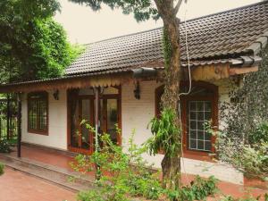 a white house with a tree in front of it at căn 3 ngủ in Ấp Tân Long