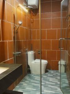 a bathroom with a toilet and a glass shower at căn 3 ngủ in Ấp Tân Long