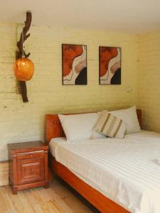 a bedroom with a bed with three pictures on the wall at căn 3 ngủ in Ấp Tân Long