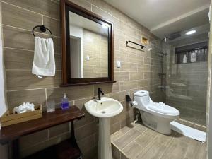 a bathroom with a sink and a toilet and a mirror at Arrecife Punta Uva - Hospedaje, bar y restaurante - Frente al mar in Punta Uva +17 photos