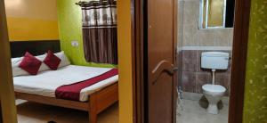 a small bedroom with a bed and a toilet at Zeromiles Green Park in Digha