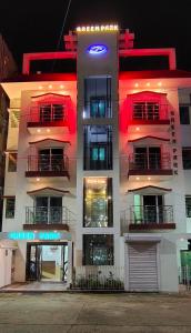 a tall white building with a neon sign on it at Zeromiles Green Park in Digha +63 photos