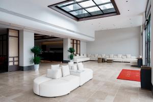 a lobby with white furniture and a skylight at vangvieng THAVIKUN HOTEL in Vang Vieng