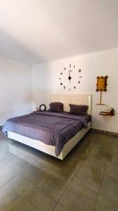 a bedroom with a bed with a clock on the wall at Dom Dom Guest House Gili Gede in Gili Gede