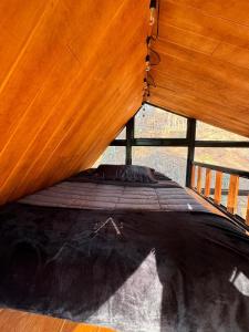 a bed in a room with a wooden wall at En medio de la nada in Mazamitla