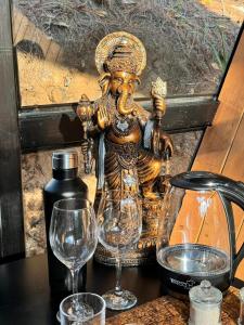 a statue sitting on a table with two wine glasses at En medio de la nada in Mazamitla
