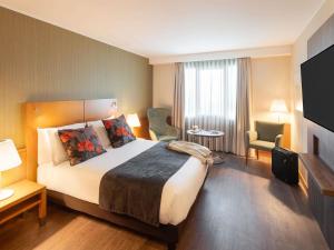 a hotel room with a large bed in a room at Hotel Mercure Porto Gaia in Vila Nova de Gaia