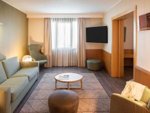 a living room with a couch and a tv at Hotel Mercure Porto Gaia in Vila Nova de Gaia +136 photos