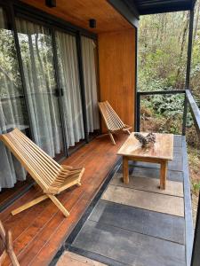 two chairs and a table on a screened in porch at Disfruta del Bosque in Mazamitla