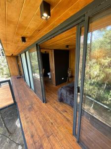 a room with a bed on a wooden deck at Disfruta del Bosque in Mazamitla