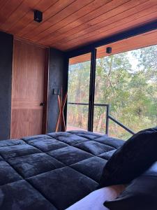 a bedroom with a bed and a large window at Disfruta del Bosque in Mazamitla +25 photos