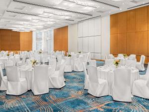 ein Raum mit weißen Tischen und weißen Stühlen und Tischsucher in der Unterkunft Sofitel Montreal Golden Mile in Montreal