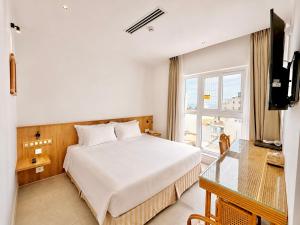 a hotel room with a bed and a window at Green World Hotel Nha Trang in Nha Trang