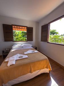 a bedroom with two beds and two windows at Pousada Vila dos Santos in Porto De Galinhas