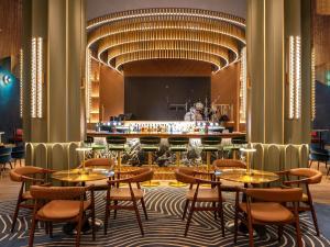 a restaurant with tables and chairs and a bar at Novotel Dubai World Trade Centre in Dubai