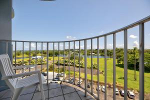 a balcony with a chair and a view of a park at Hilo Lagoon Centre - 4BR Condos - Sleeps 12 in Hilo
