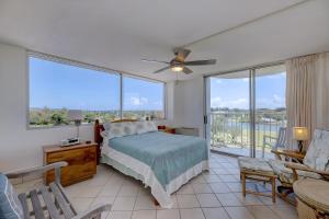 a bedroom with a bed and a view of the water at Hilo Lagoon Centre - 4BR Condos - Sleeps 12 in Hilo