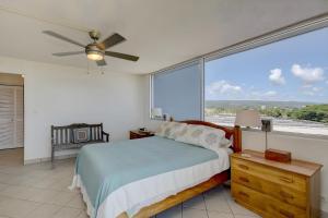 a bedroom with a bed and a large window at Hilo Lagoon Centre - 4BR Condos - Sleeps 12 in Hilo +22 photos