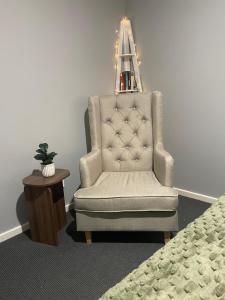 a chair sitting in a room next to a table at The Snug Suite in Cooranbong