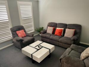 a living room with two couches and a coffee table at The Snug Suite in Cooranbong